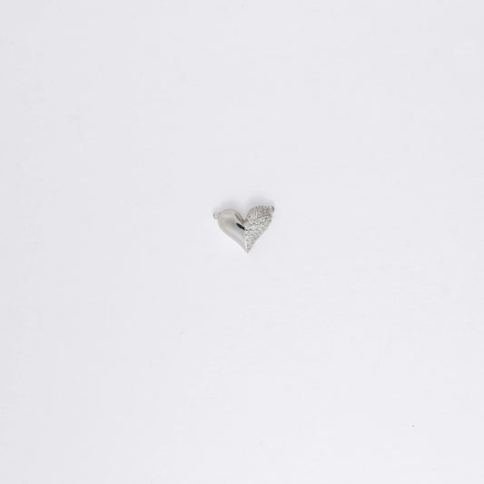 Silver heart-shaped charm on a light gray background