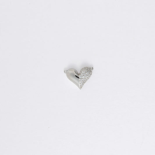 Silver heart-shaped charm on a light gray background