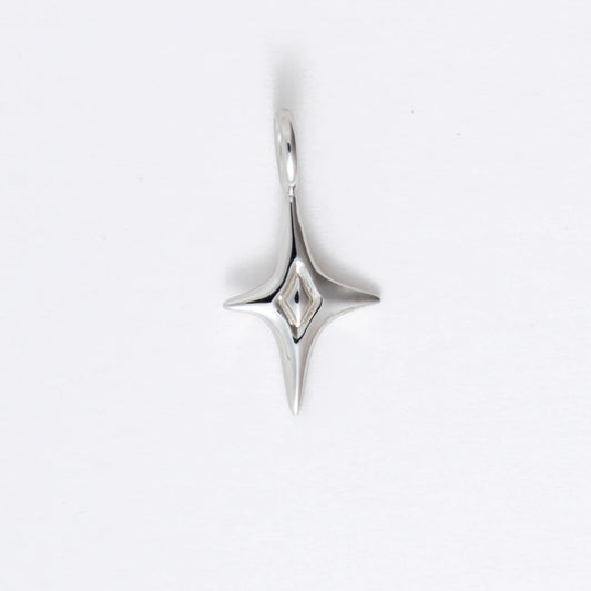 Silver star-shaped charm on a light gray background