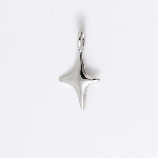 Silver star-shaped charm on a light gray background