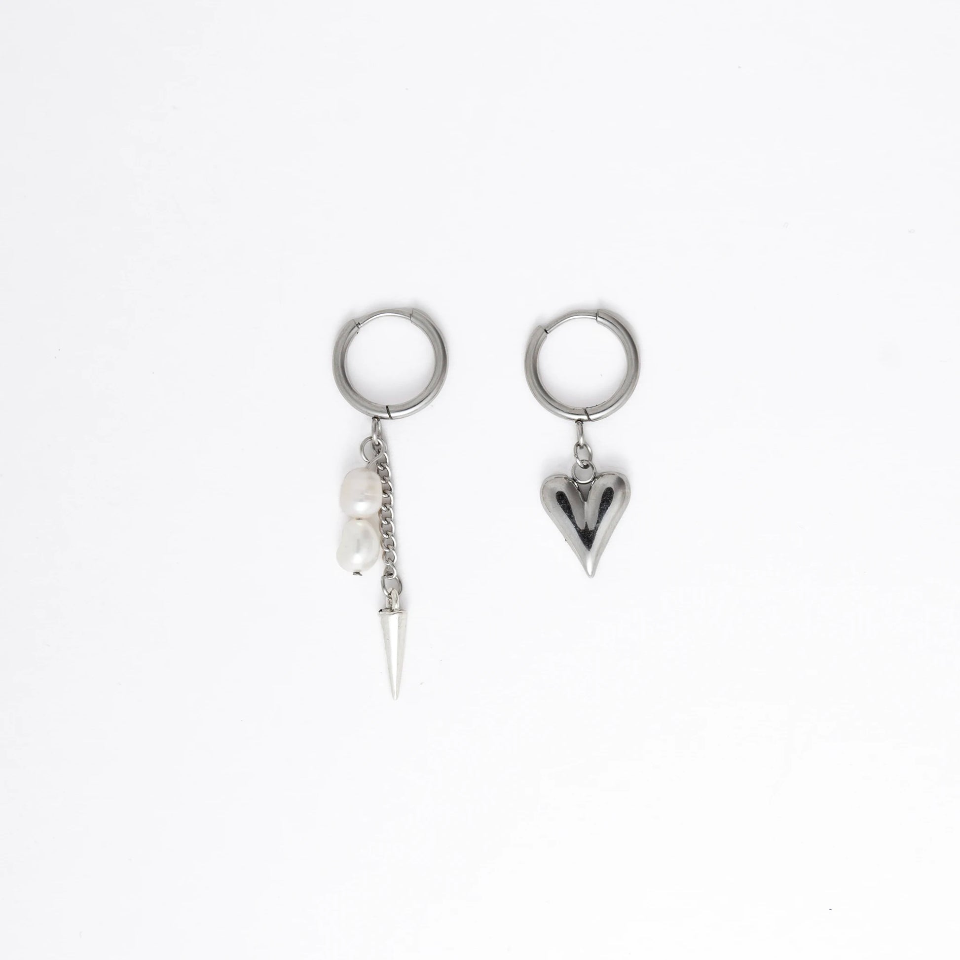 Pair of silver hoop earrings with unique heart and arrow designs on a white background