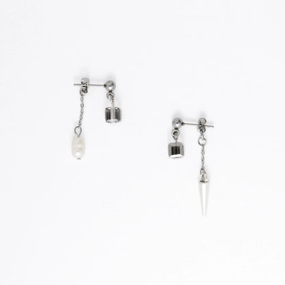 Pair of silver earrings with chain and pendant on a white background