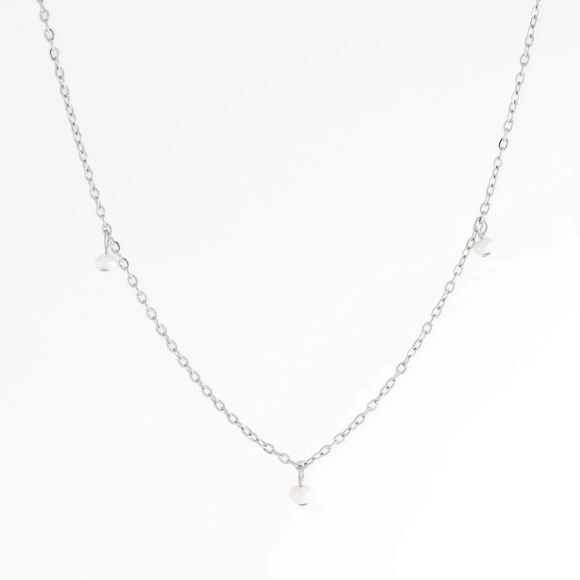 Silver necklace with a small pendant on a white background