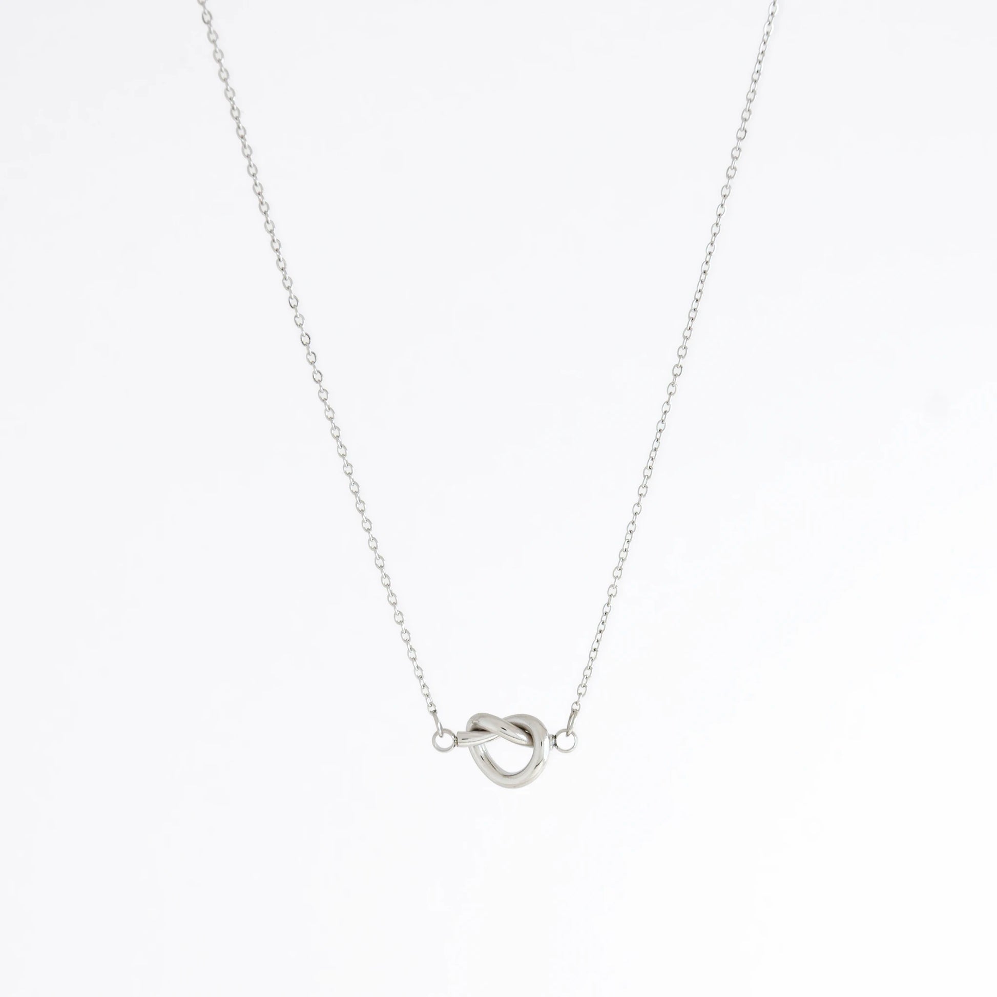 Silver necklace with a unique pendant design on a white background