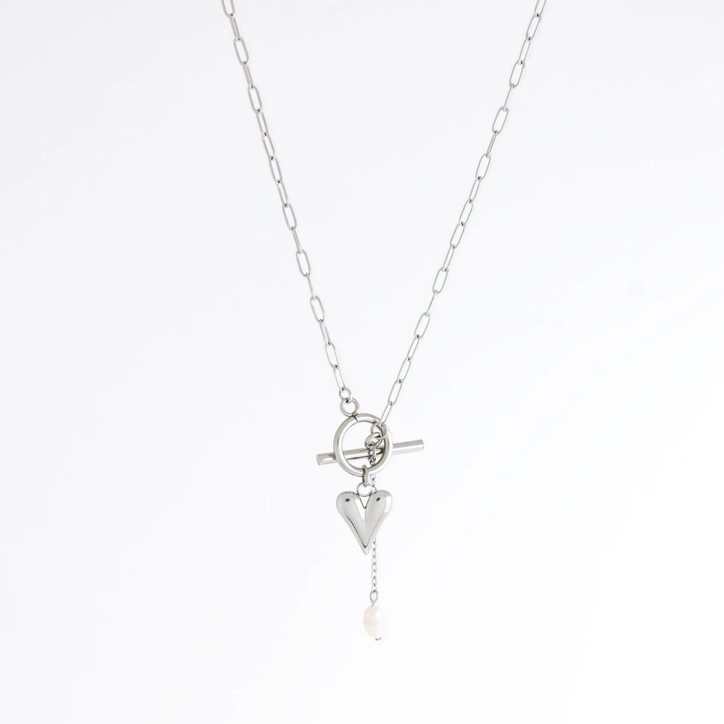 Silver necklace with heart and pearl pendant on a white background