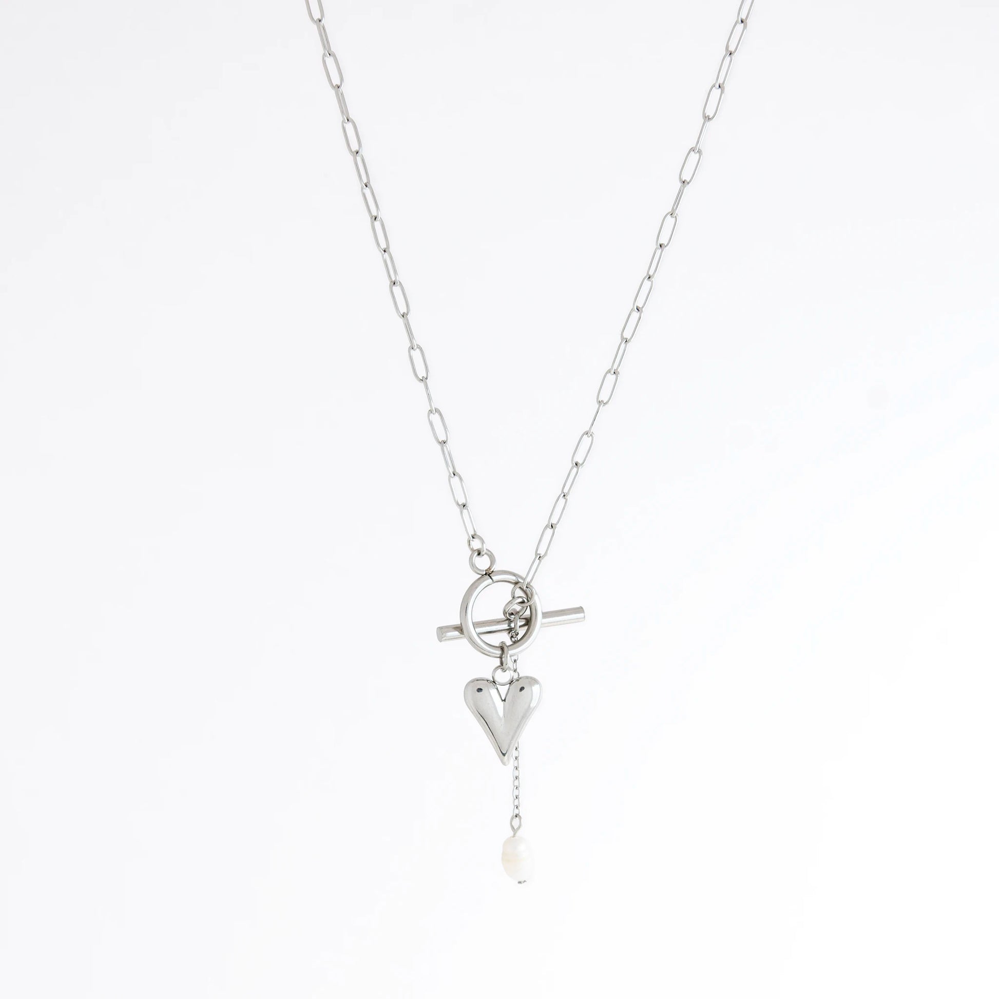 Silver necklace with heart and pearl pendant on a white background