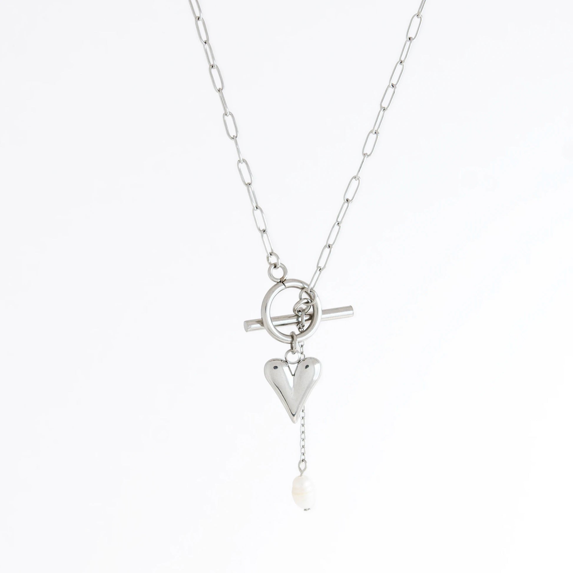 Silver necklace with heart and pearl pendant on a white background