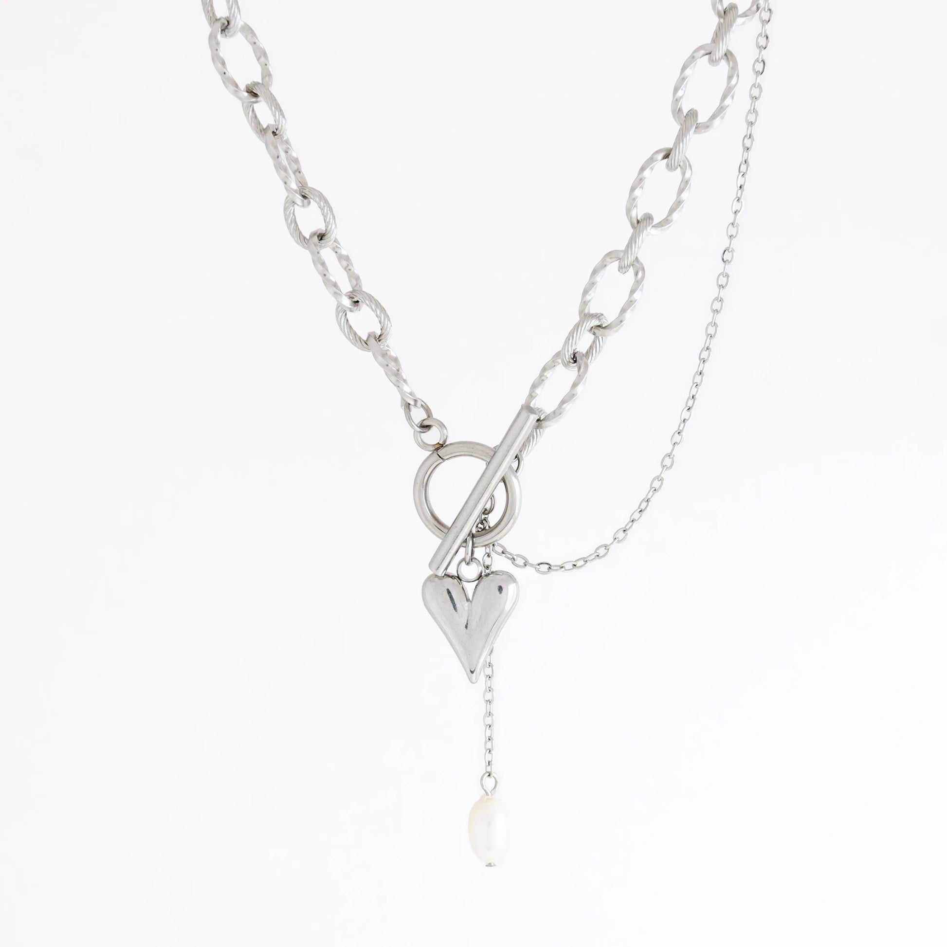 Silver paperclip necklace with heart and pearl pendant on a white background