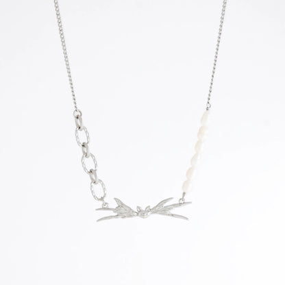 Silver necklace with leaf-like pendants on a white background