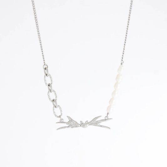 Silver necklace with leaf-like pendants on a white background