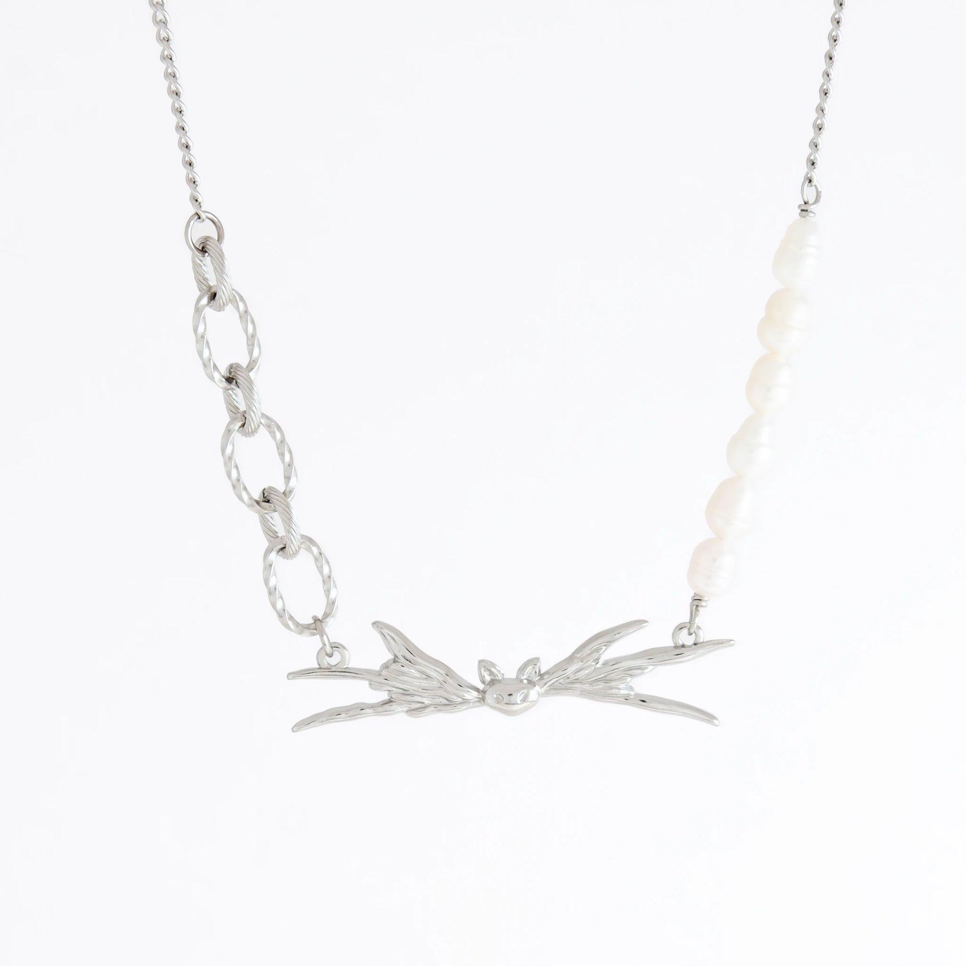Silver necklace with leaf-like pendant on a white background