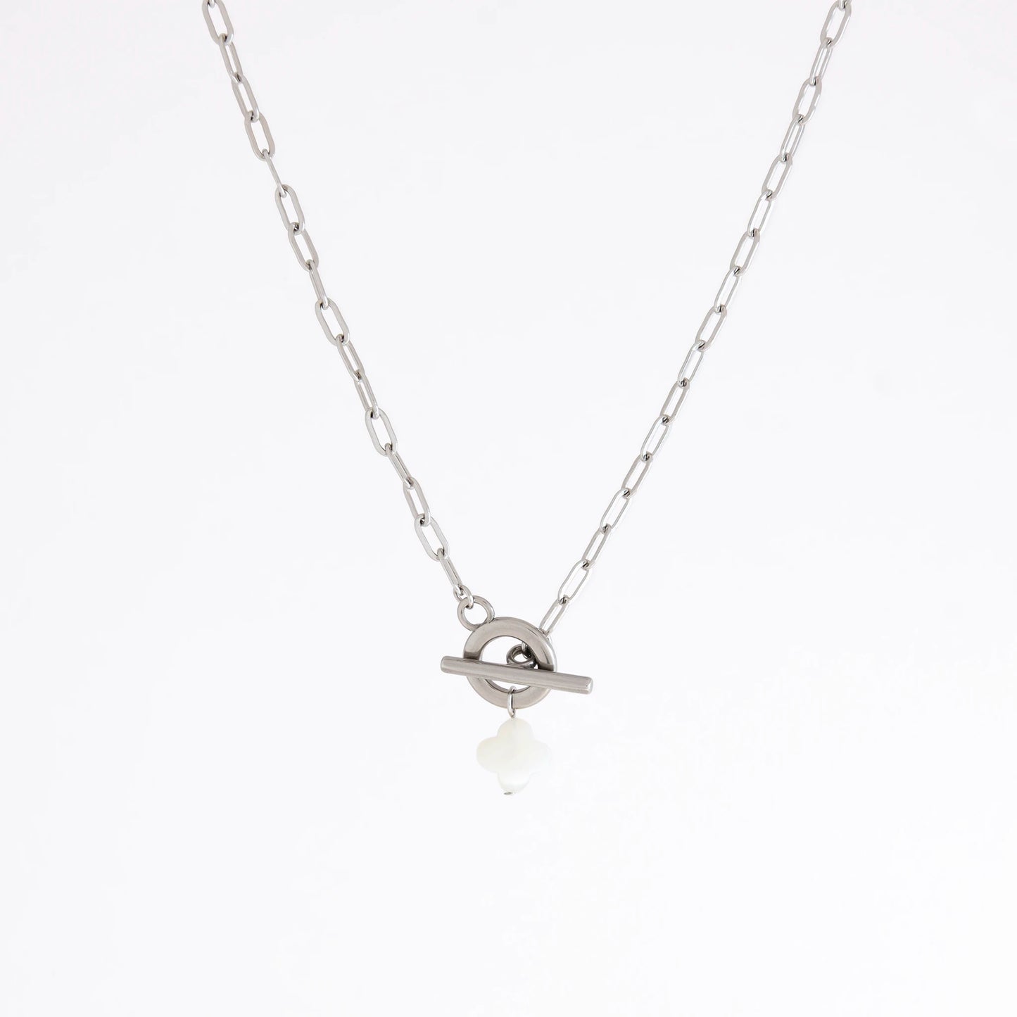 A silver chain necklace with a toggle ring pendant and a small white teardrop charm, shown against a plain white background.