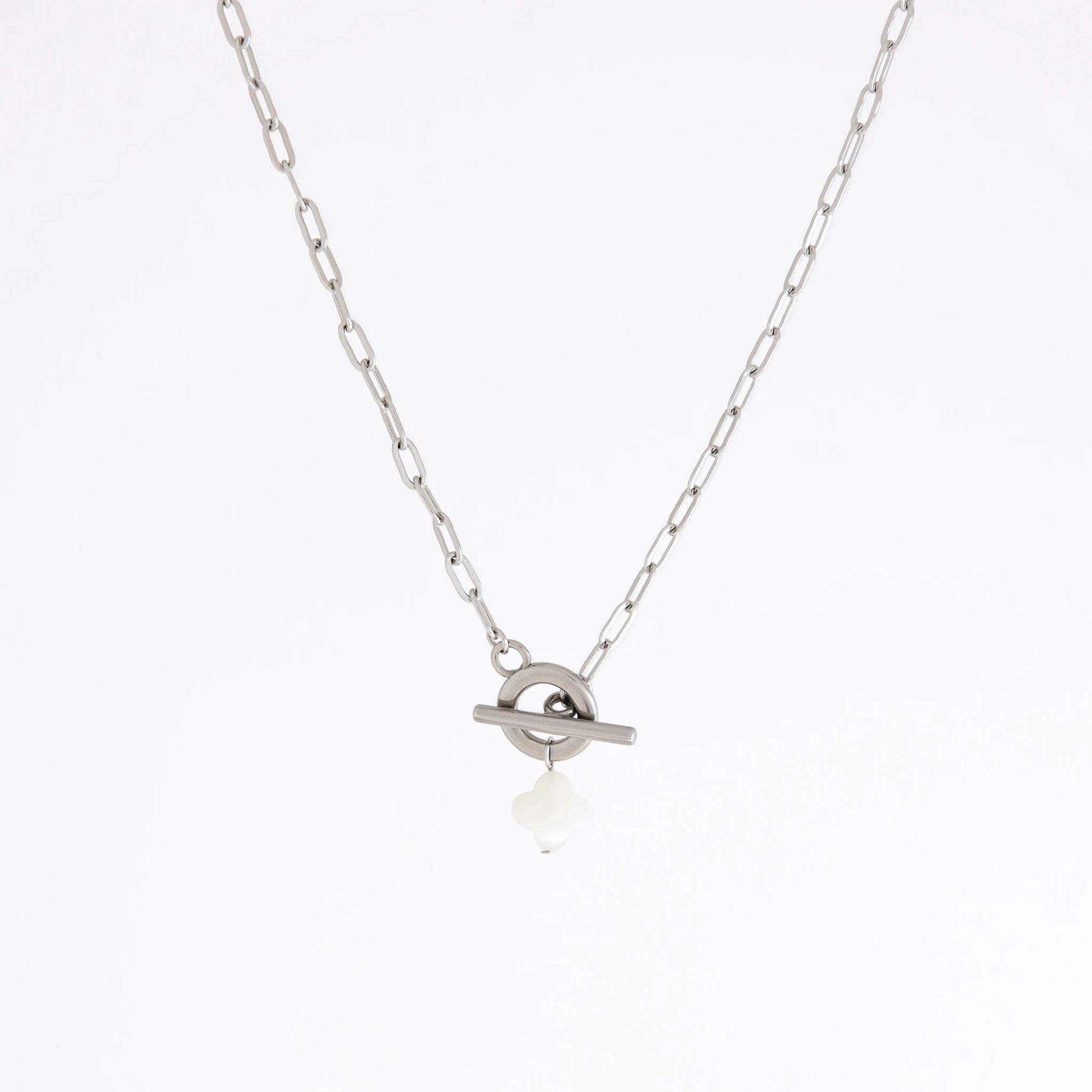 A silver chain necklace with a toggle ring pendant and a small white teardrop charm, shown against a plain white background.