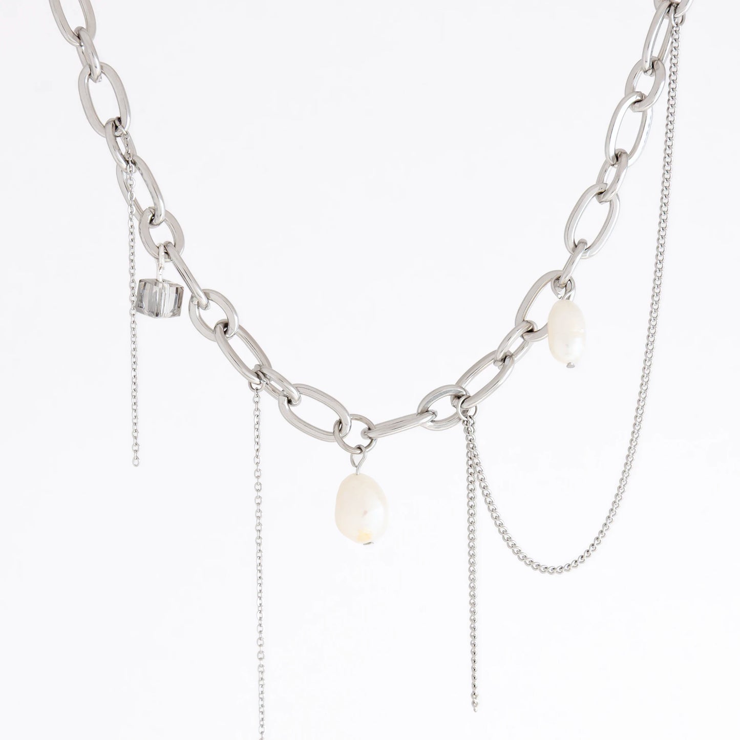 A silver-toned chain necklace featuring chunky oval links, delicate chain drapes, and three small white baroque pearl-like beads, shown against a plain white background.