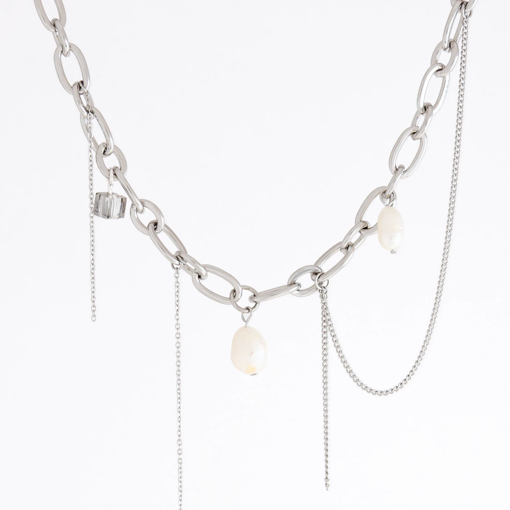 A silver-toned chain necklace featuring chunky oval links, delicate chain drapes, and three small white baroque pearl-like beads, shown against a plain white background.