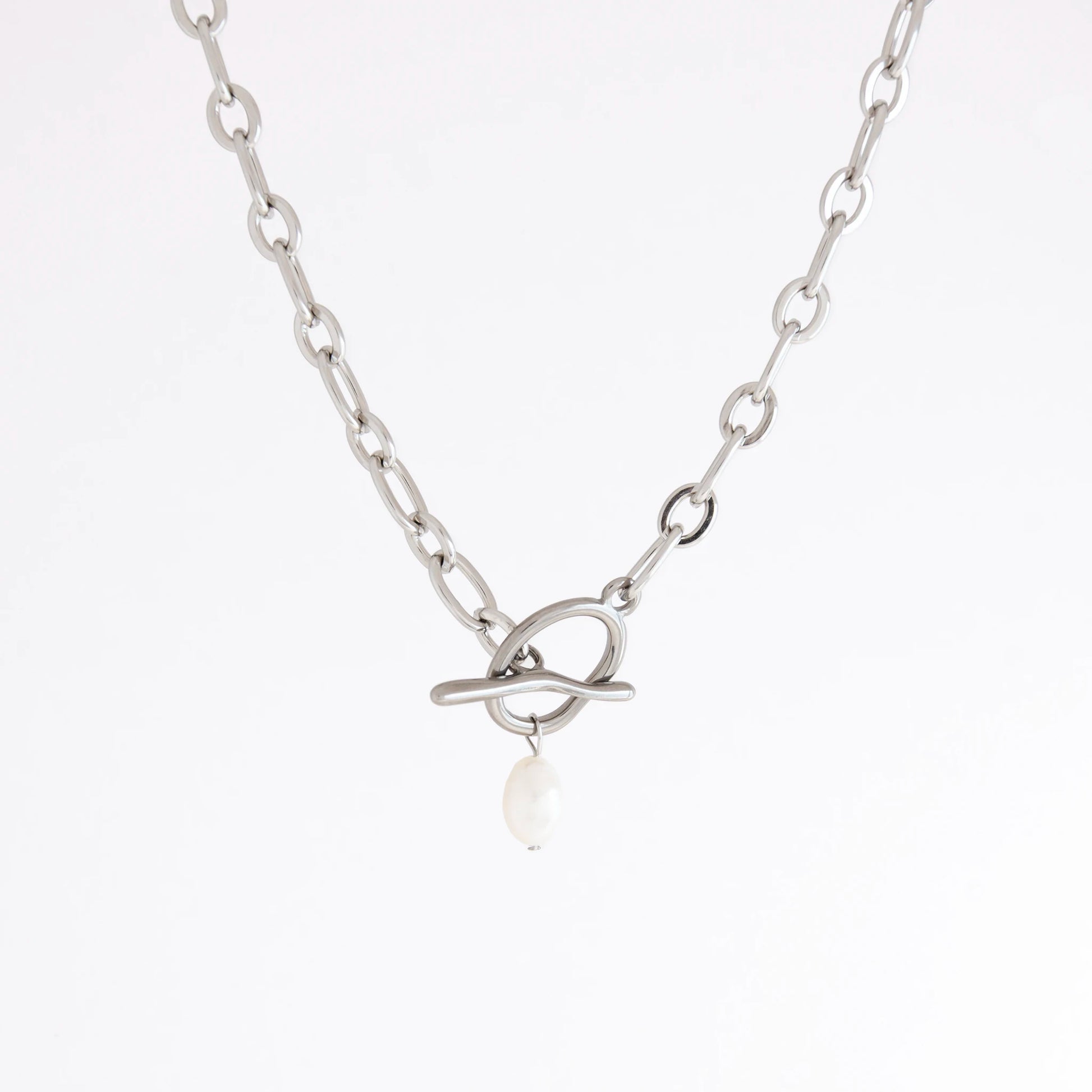 A silver chain necklace featuring a unique interlocking ring clasp with a single white pearl dangle, shown against a plain white background.