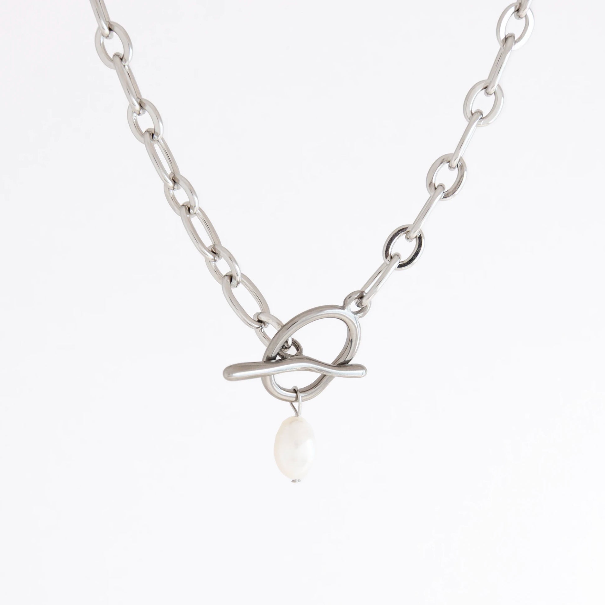 A silver-toned chain necklace with a unique interlocking loop clasp and a dangling white pearl, shown against a plain white background.