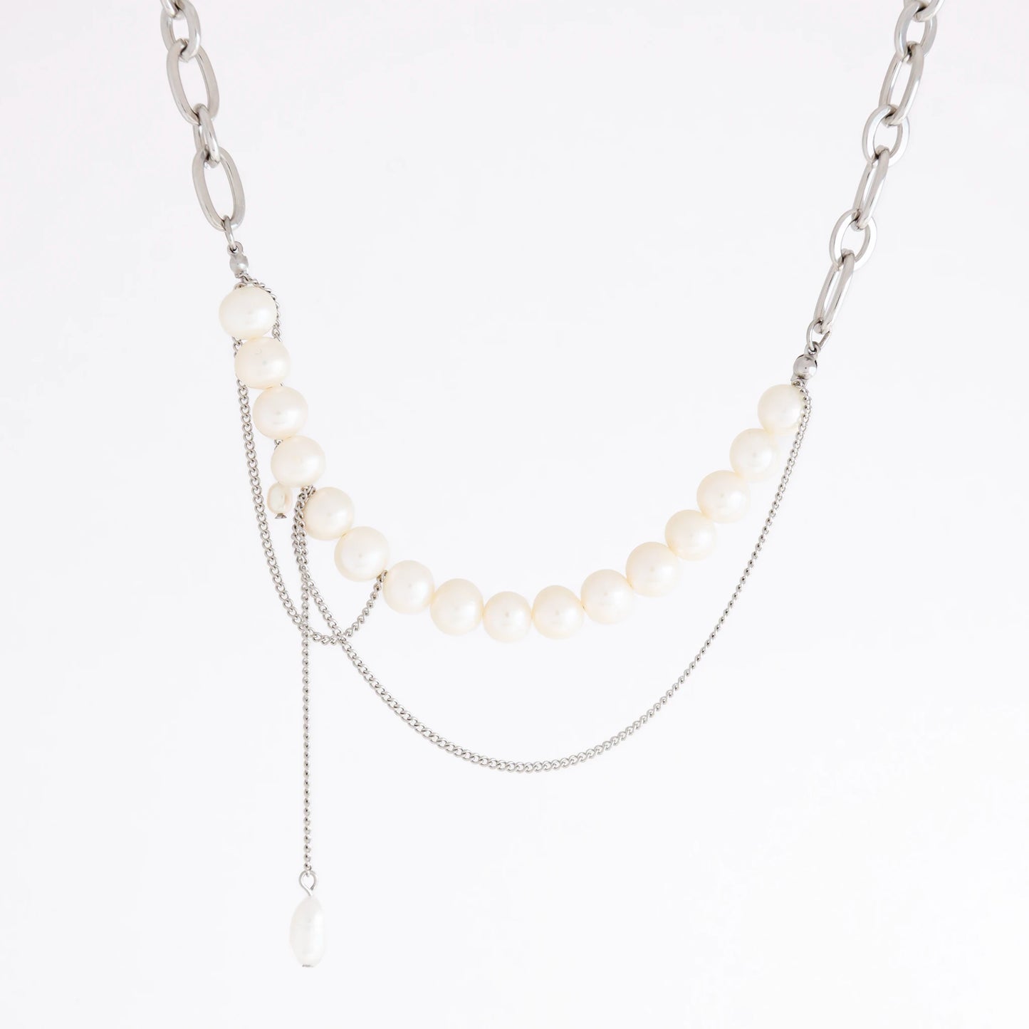 A silver-tone layered necklace featuring a curved strand of white pearls, a chunky silver chain, delicate chain drapes, and a small teardrop pearl pendant, shown on a plain white background.