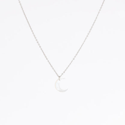 A delicate silver chain necklace featuring a small crescent moon pendant made of milky white mother-of-pearl, set against a seamless white background.
