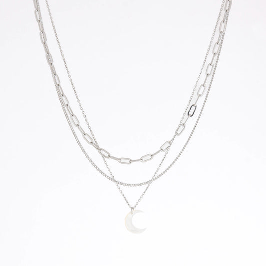 A layered silver necklace set featuring three distinct chain styles: a paperclip chain, a delicate cable chain, and a fine chain with a crescent moon pendant, displayed on a clean white background.