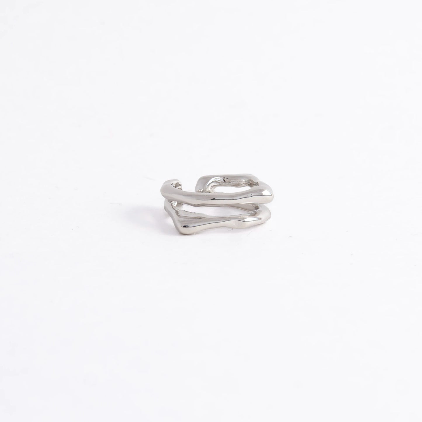A polished silver-toned ring with an abstract, wavy, multi-layered design, photographed on a seamless white background.