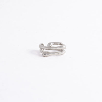 A polished silver-toned ring with an abstract, wavy, multi-layered design, photographed on a seamless white background.