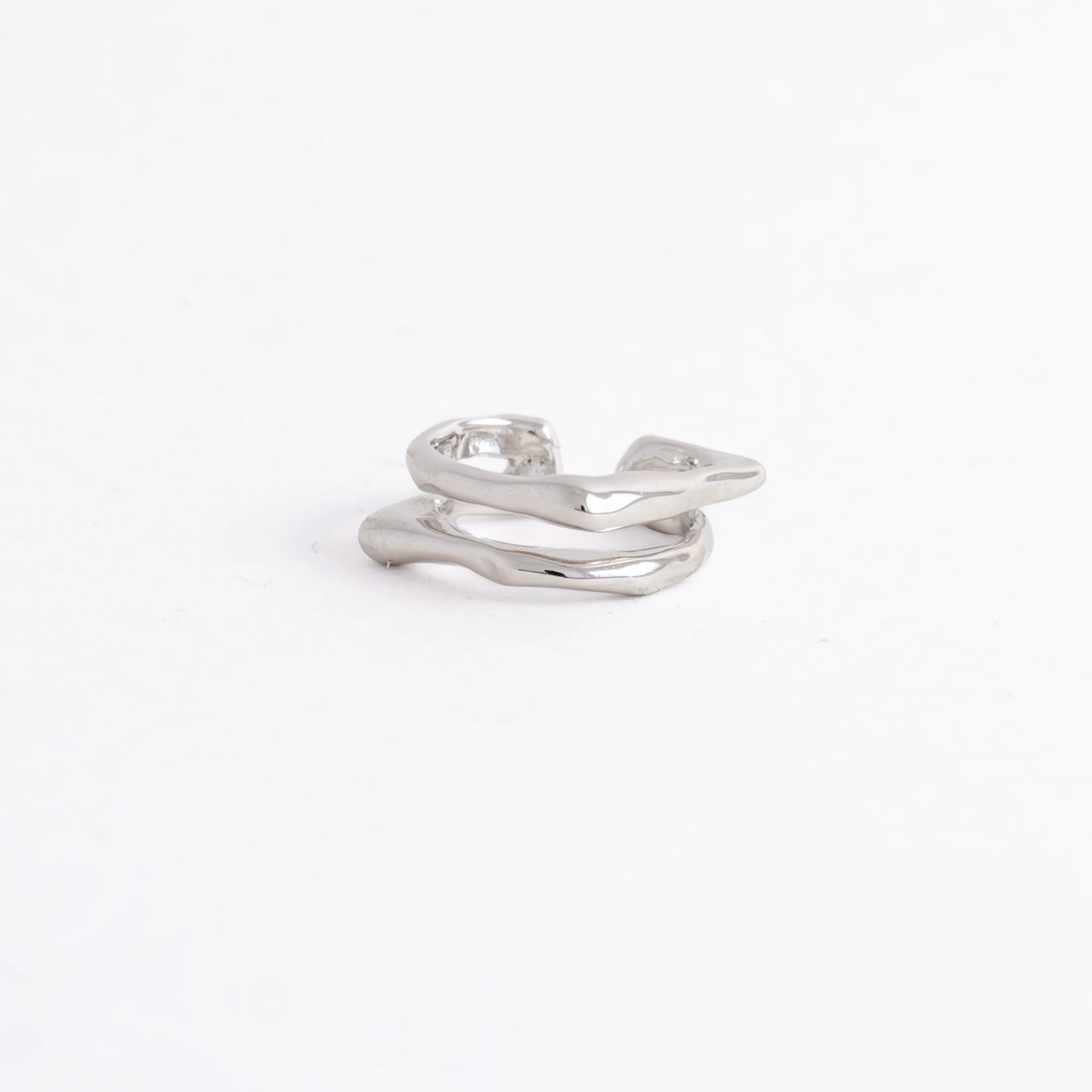 A polished silver-toned ring with an organic, wavy, multi-layered design, photographed on a seamless white background.
