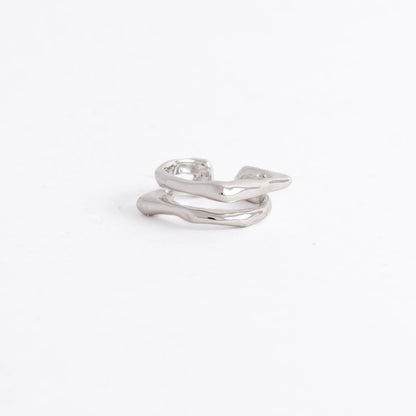 A polished silver-toned ring with an organic, wavy, multi-layered design, photographed on a seamless white background.