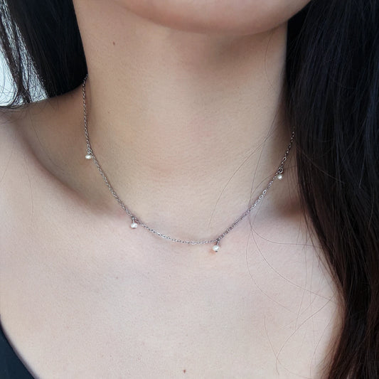 Close-up of a delicate necklace on a person's neck with a blurred background