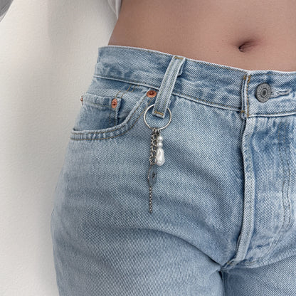 Keychain with box chain, compass and star charms hooked on denim pants