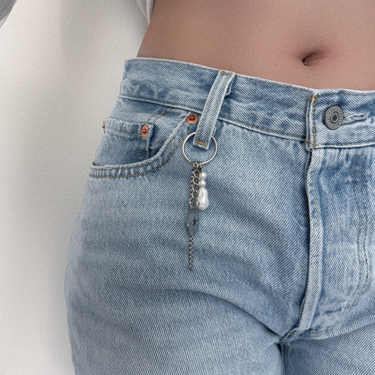 Keychain with box chain, compass and star charms hooked on denim pants