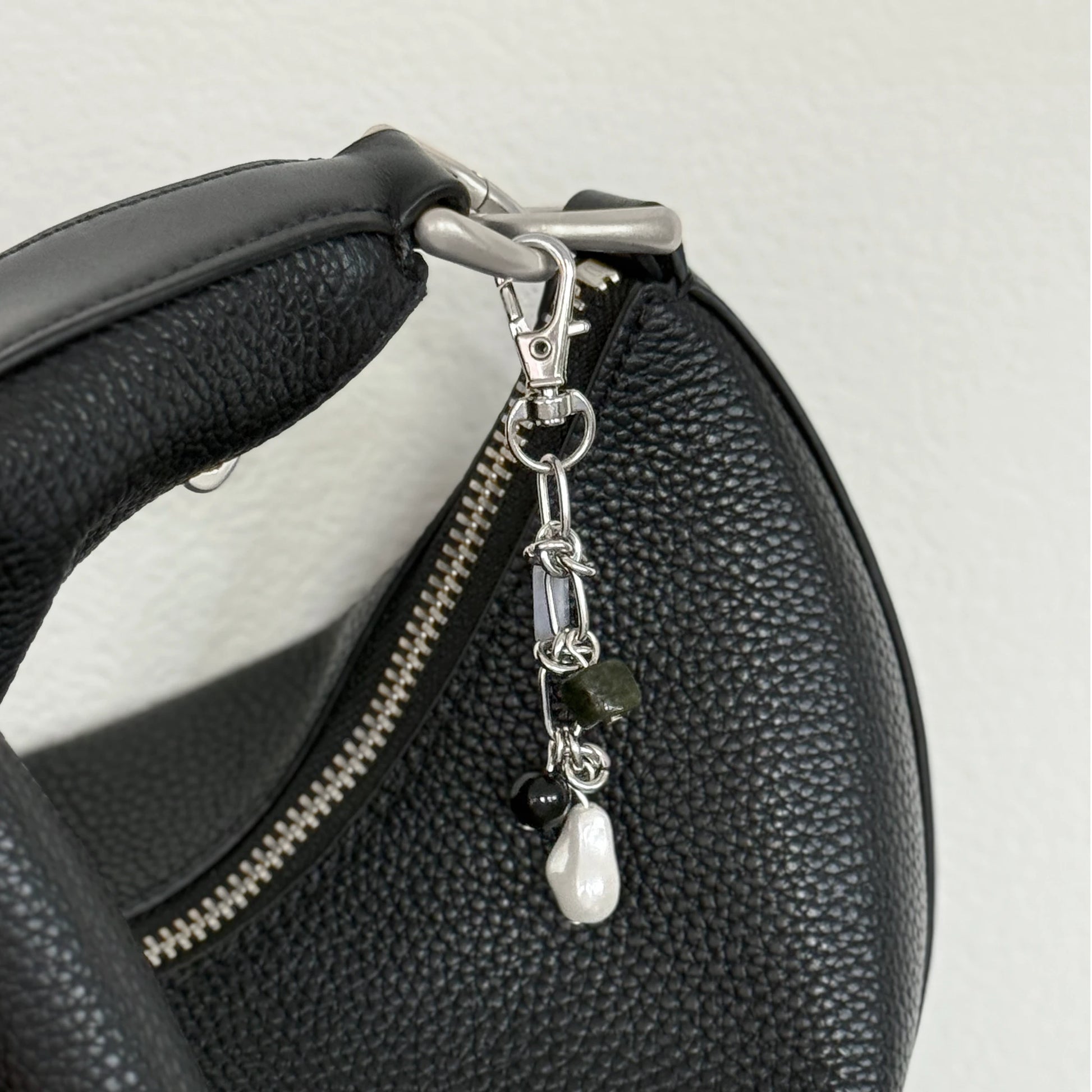 Multi-stone keychain hanging on a black purse