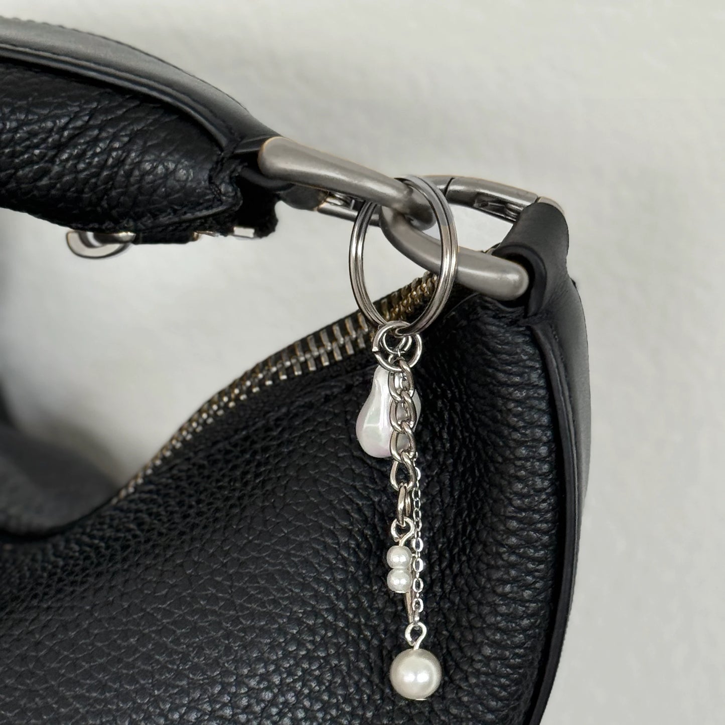 Silver keychain with a small dagger charm on a white background