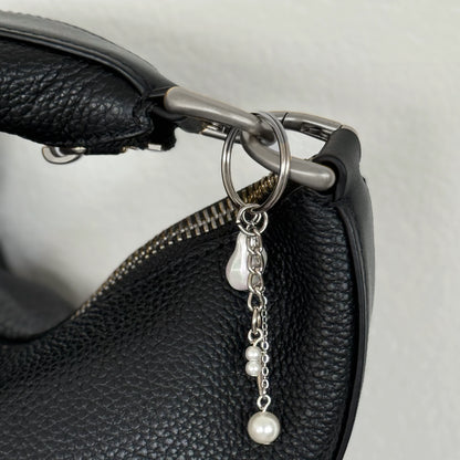 Silver keychain with a small dagger charm on a white background