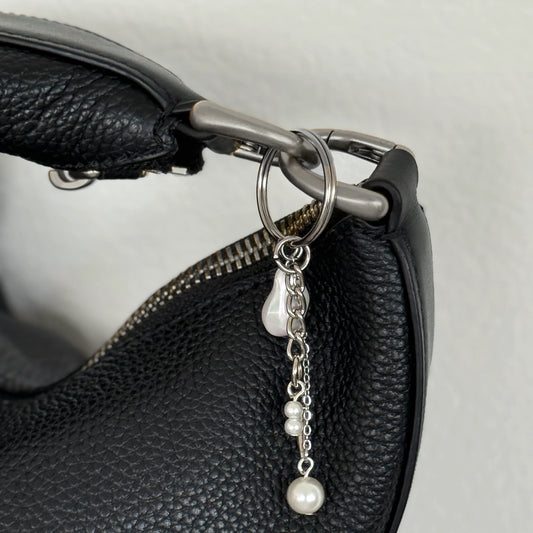 Silver keychain with a small dagger charm on a white background