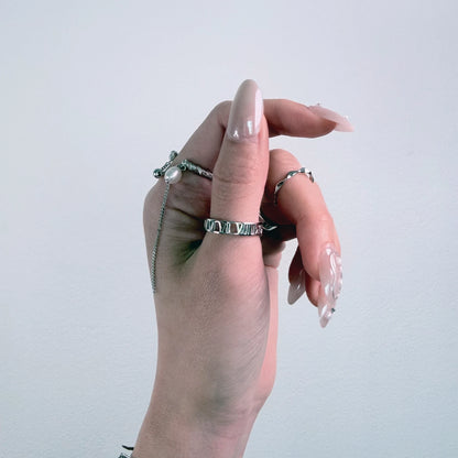 Sterling silver roman numeral ring on a gray background